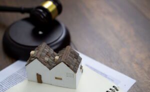 Small model houses and a legal gavel on documents, representing property distribution and the services of a will lawyer in Perth.